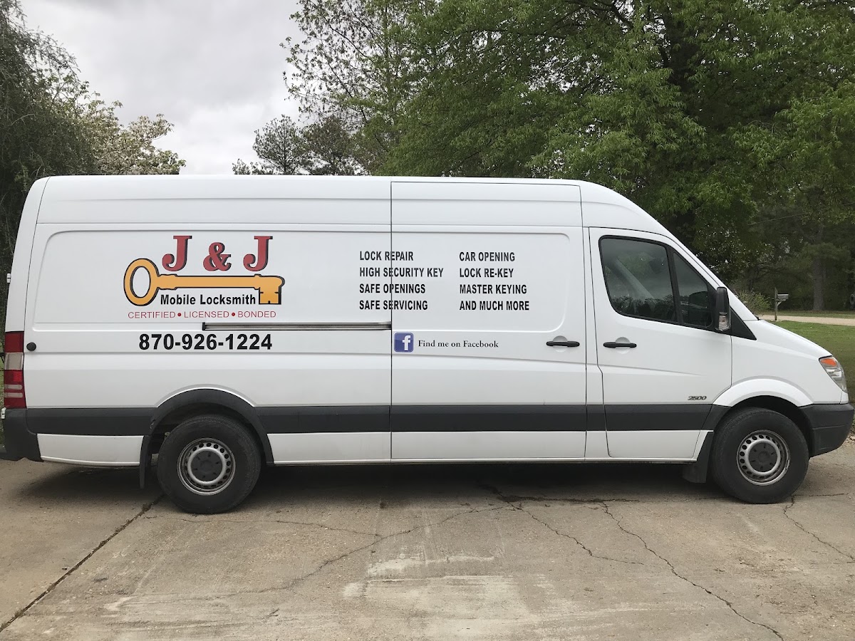 The white J & J Mobile Locksmith van with its service list on the side